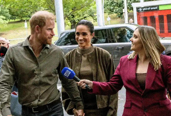 Meghan Markle in a khaki St. Agni suit and Prince Harry in Australia.