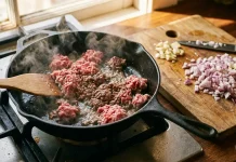 Ten tani produkt z kuchni odmieni Twoje dania: błąd, który popełnia co druga osoba podczas smażenia Обсмажування м'ясного фаршу з червоною цибулею та спеціями на гарячій пательні.