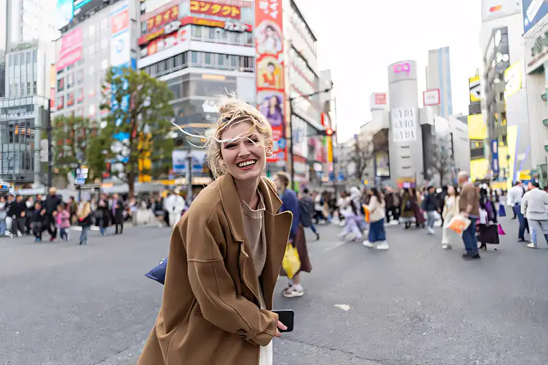 Bright neon lights and crowds at the famous Shibuya Crossing in Tokyo Japan.