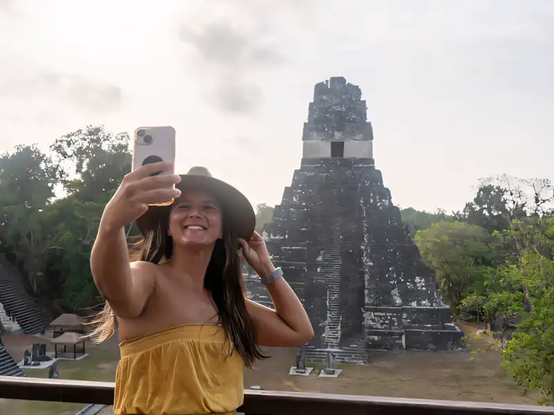 Ancient Mayan step pyramid rising out of the dense jungle canopy in Central America.