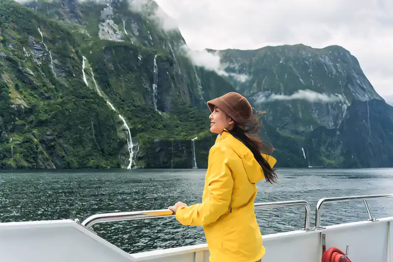 Majestic fjord with steep mountains rising out of deep blue water at Milford Sound New Zealand.