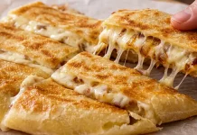 The One Pan Potato Trick That Makes The Ultimate Crispy Snack UA: Смажений золотистий картопляний коржик із розплавленим сиром моцарела на дерев'яній дошці | PL: Smażona złota tortilla ziemniaczana z roztopionym serem mozzarella na desce | EN: Fried golden potato tortilla with melted mozzarella cheese on a wooden board
